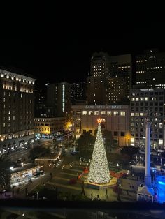 a large christmas tree is lit up in the city