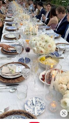 a long table is set with flowers and plates