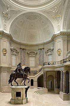 a black and white photo of a horse statue in a large room with high ceilings