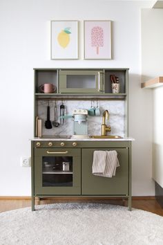 a kitchen with green cabinets and white rug