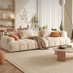 a living room filled with lots of furniture and plants on the wall behind the couch