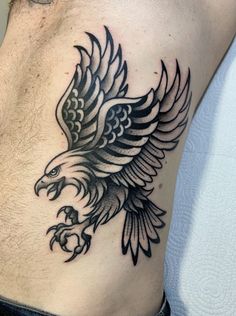 an eagle tattoo on the side of a man's stomach is shown in black and white