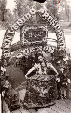 an old black and white photo of a woman sitting on the back of a boat