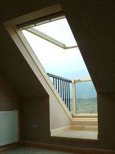 an empty room with a skylight in the corner and a radiator on the wall