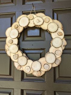 a wreath made out of logs hanging on a door