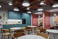 an open kitchen and dining area with round tables