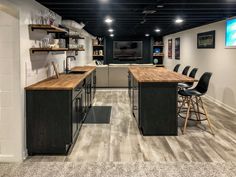 a large open concept kitchen and dining area with bar stools, counter tops, and shelving