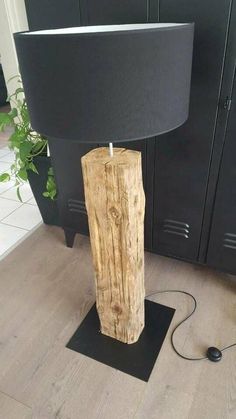 a table lamp made out of wood with a black shade on the top and bottom