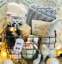 a basket filled with lots of stuff sitting on top of a fur covered floor next to candles