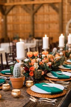 the table is set with green and white place settings, orange flowers, candles, and succulents