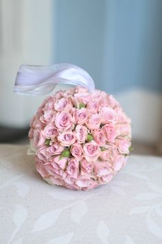 a bouquet of pink roses sitting on top of a table