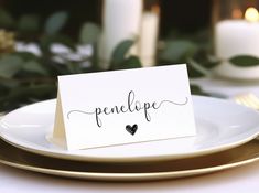 a place card on a plate with candles in the background