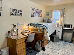 a bedroom with a bed, desk, and pictures on the wall in front of it