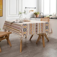 a kitchen with a table, chairs and potted plant on the counter in front of it