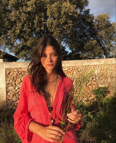 a woman in a red dress holding a plant