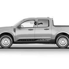 a silver pick up truck parked in front of a white background with the door open