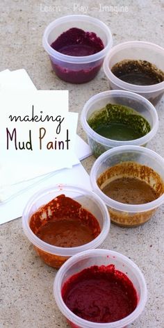 six different colored sauces in plastic containers on a table with utensils and paper towel