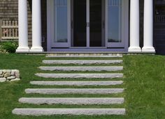 the steps lead up to the front door of a house with white pillars and windows