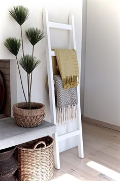 a white ladder sitting next to a potted plant