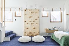 a bedroom with two beds and a climbing wall