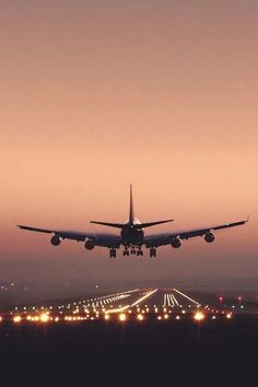 an airplane is taking off from the runway at sunset or dawn with its landing gear down