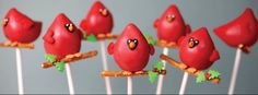 small red birds sitting on top of sticks with toothpicks sticking out of them