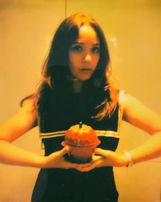 a woman holding a cupcake in front of her face