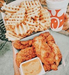 fried chicken and waffles are on the table with two cups of coffee next to them