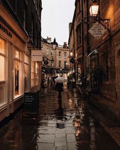 people walking down an alley way in the rain