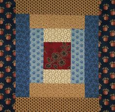 a quilted wall hanging with red, blue and yellow flowers on it's sides