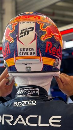 a person wearing a red bull racing helmet