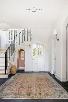 Elevate your entryway decor with the Kate Marker Home collection of vintage area rugs, light fixtures, and wall decor. Designed by Kate Marker Interiors, this space features a charming dutch door, arches, and a gorgeous staircase design. Head to katemarkerhome.com to get inspired and create a welcoming space for you and your guests that embodies a sense of beauty, balance, and belonging. Entry Way Table Ideas, Home Entry Way, Entryway Styling, Entry Way Decor, Entry Way Table, Foyer Modern, Console Table Styling, Best White Paint