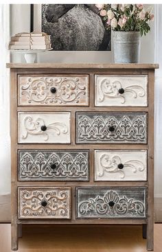 an ornate dresser with drawers and flowers on top