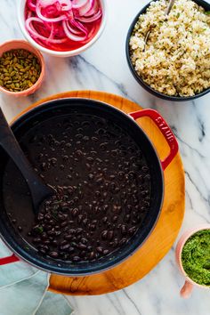 beans and rice are being cooked in a pot on the counter with other ingredients around it