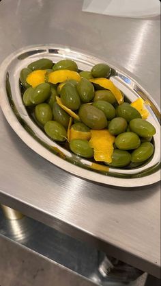 green and yellow olives in a bowl on a stainless steel table