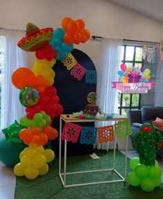 a birthday party with balloons and decorations in the shape of a cactus, taco