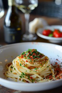 a white bowl filled with spaghetti and topped with parmesan sprinkles