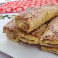 some food is on a white plate and has powdered sugar on top, along with a red napkin