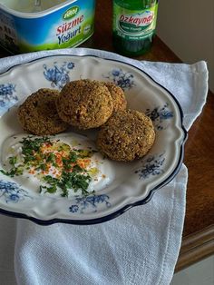 three food items on a plate next to a container of yogurt and a napkin