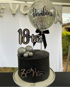 a black and white cake with balloons on top