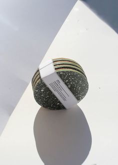 a round object sitting on top of a white table next to a tag that says,