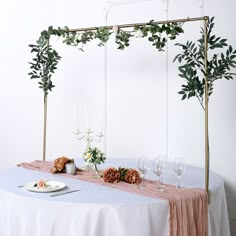 the table is set with white linens and greenery