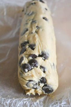 an uncooked cookie dough with chocolate chips on it sitting on plastic wrapper