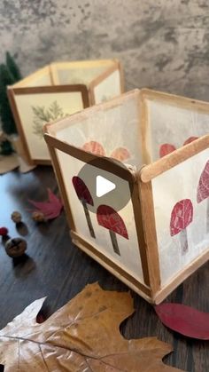 an open box sitting on top of a wooden table next to leaves and acorns