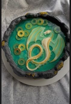 there is a cake decorated with buttons and a dragon on it