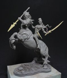 a statue of a woman riding on the back of a horse with two swords in her hand