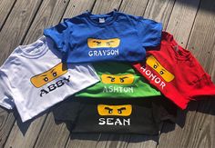 five children's t - shirts with legos on them sitting on a wooden deck