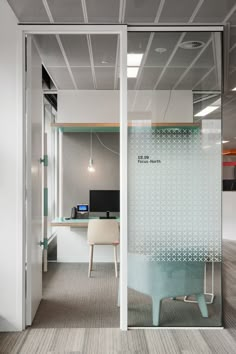 an office cubicle with glass walls and desks