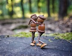 two wooden figurines are standing in the woods