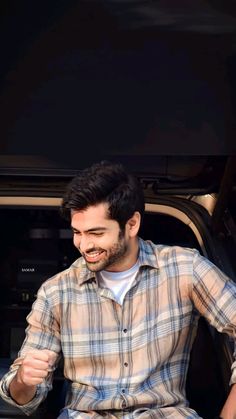 a man sitting in the back of a pickup truck with his hands on his hips